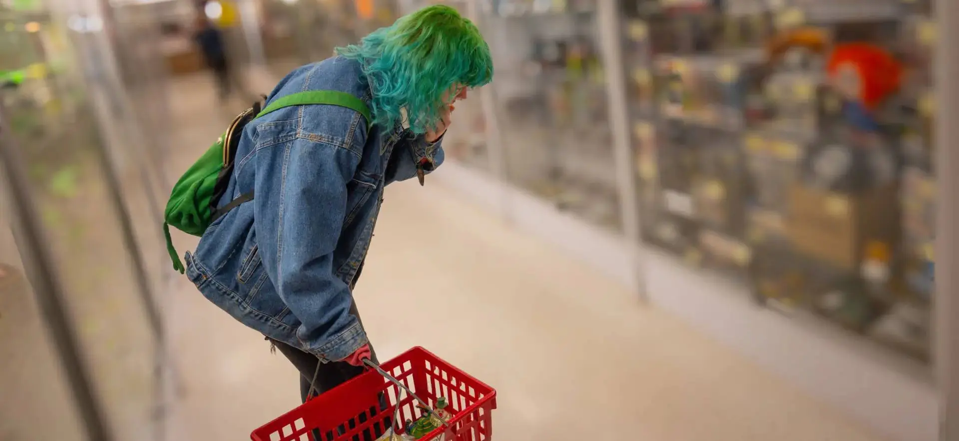 A person with blue hair is pushing a cart