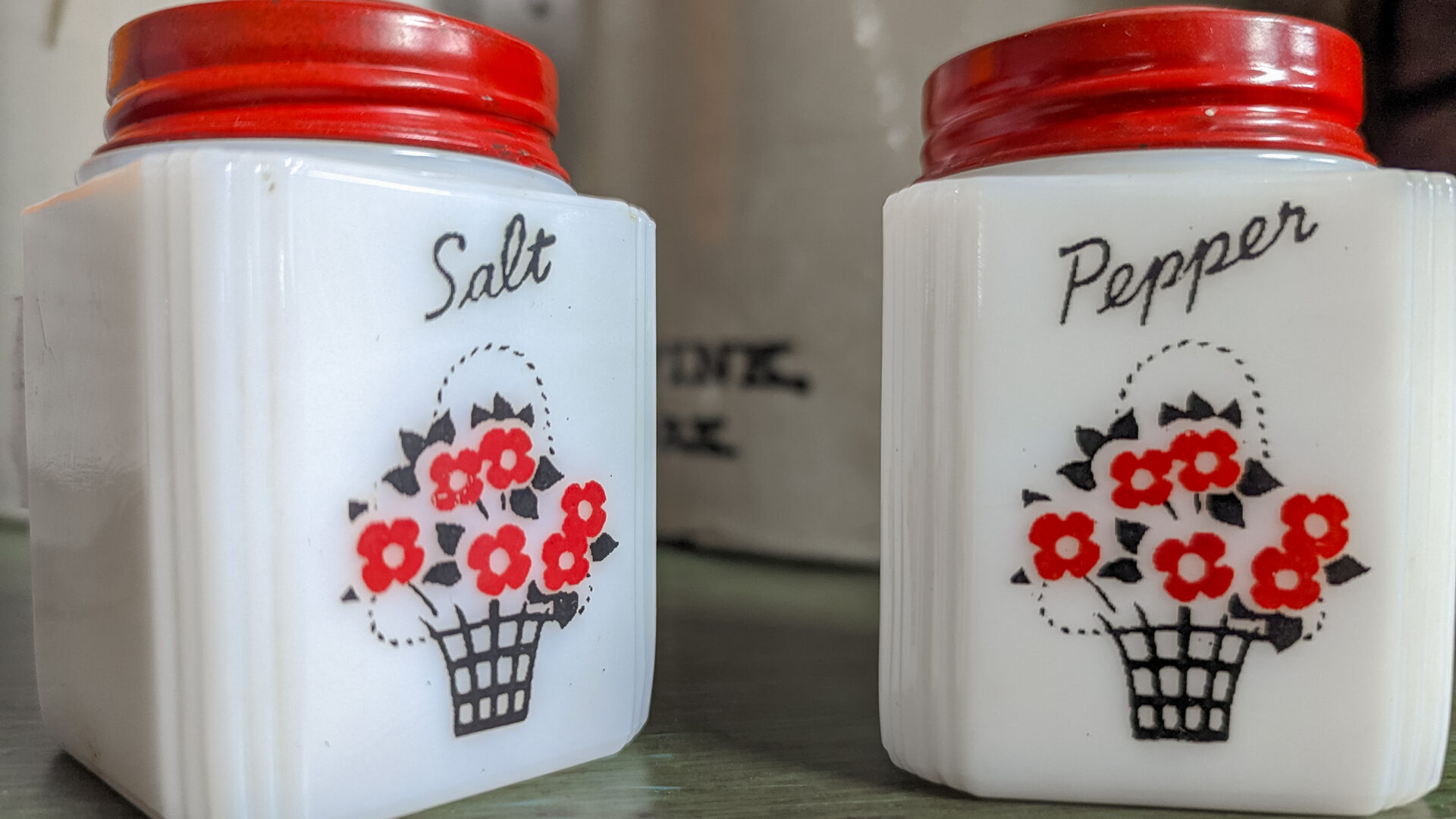 Two white and red containers with flowers on them.