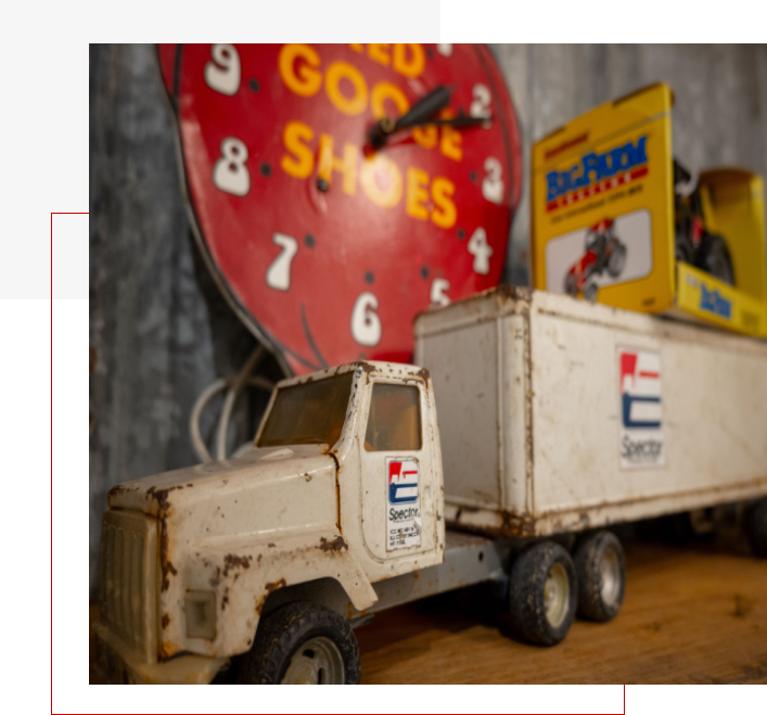 A toy truck with a clock on the wall.