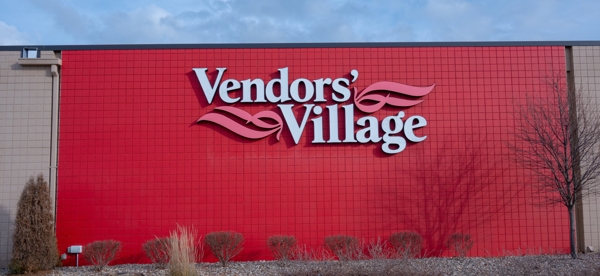 A red building with the words " vendors village ".